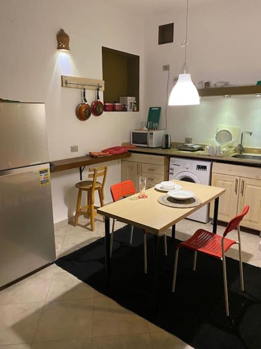 a kitchen with a table and chairs and a table and a refrigerator at Lighthouse studio in Dahab