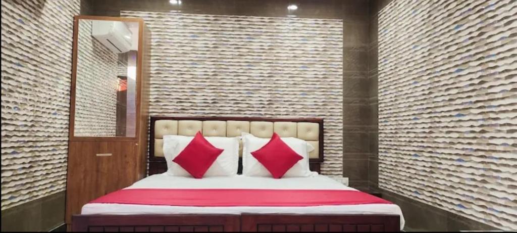 1 dormitorio con 1 cama con almohadas rojas y blancas en Supreme Hotels 2.0, en Warangal