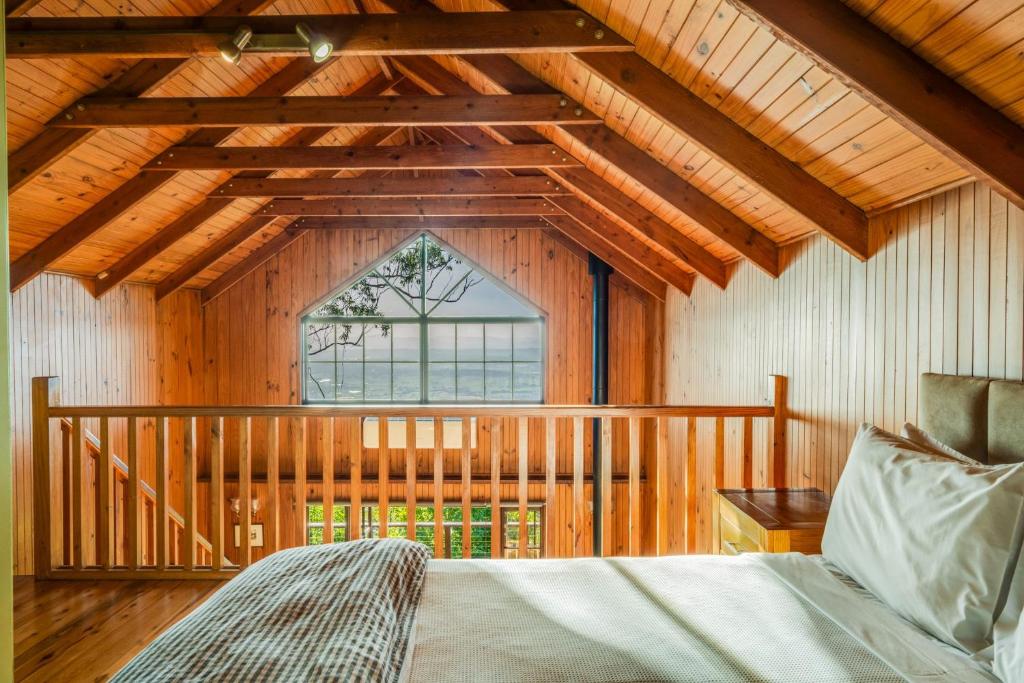 um quarto com uma cama e uma grande janela em The Polish Place em Mount Tamborine