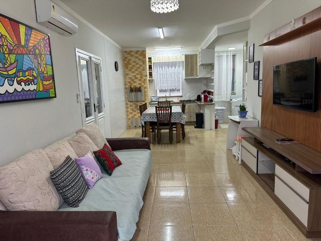 sala de estar con sofá y cocina en Praia De Palmas, apartamento 2 quartos, completo próximo a praia e todo comercio, en Governador Celso Ramos
