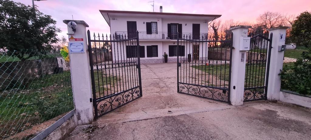 um portão em frente a uma casa branca em Casa Carmine - Casa Vacanza em Colleberardi