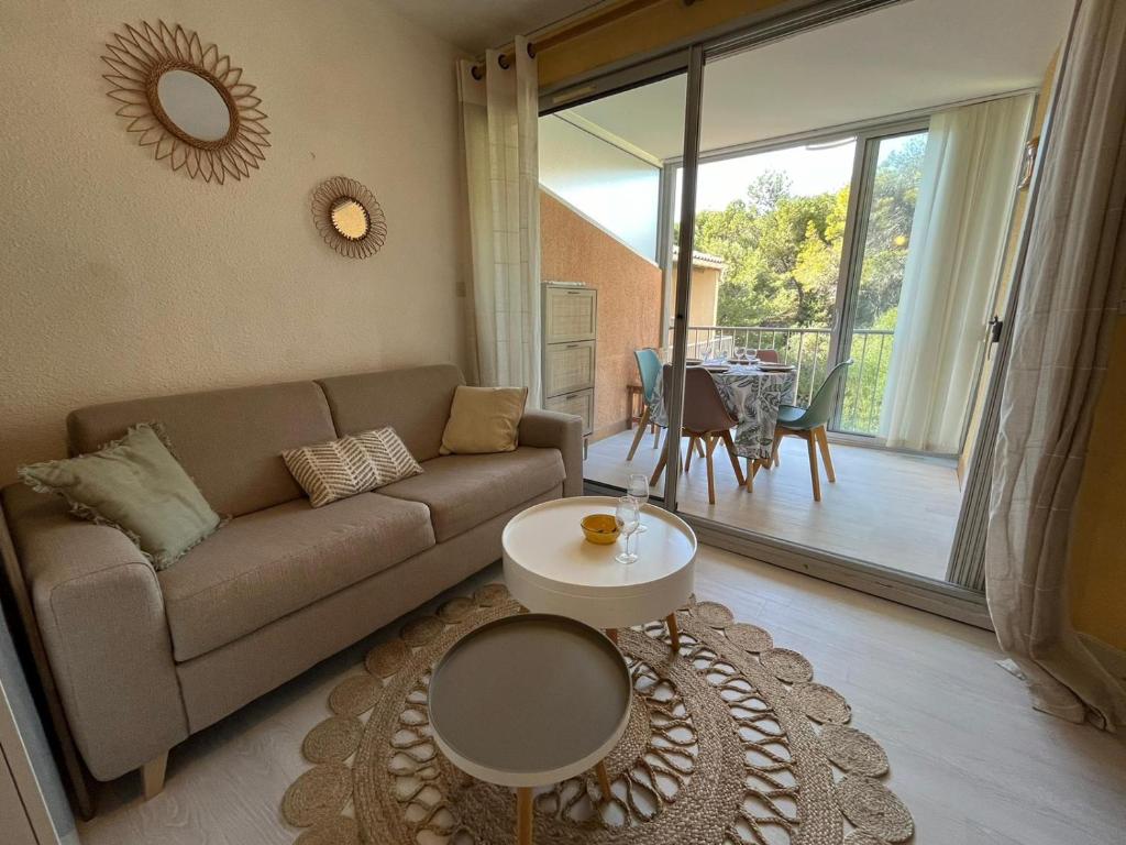 un salon avec un canapé et une table dans l'établissement Appartement T2 Cabine à 200m de la plage à Saint Pierre la mer 4OLIV70, à Saint Pierre La Mer