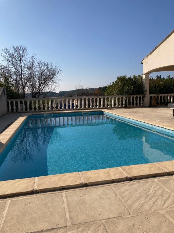 une piscine avec de l'eau bleue dans une cour dans l'établissement La villa des Geckos de Mus, à Mus