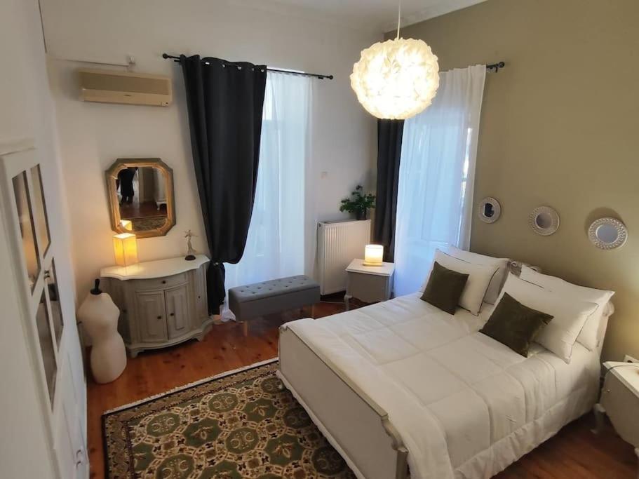 a bedroom with a white bed and a chandelier at Thalgiron, a breath away from Delphi in Ámfissa