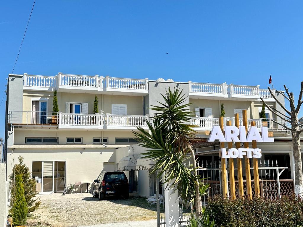 a large white building with a sign in front of it at Arial Lofts in Vlorë