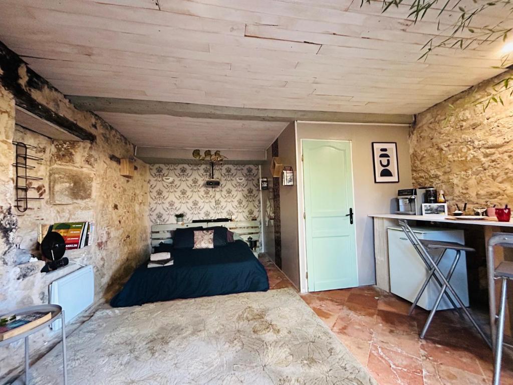 1 dormitorio con cama y pared de piedra en Chambre d’hôte avec Sauna & Jacuzzi, en Les Lèves-et-Thoumeyragues