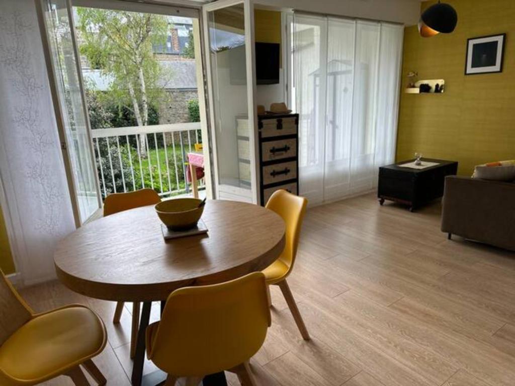 un salon avec une table et des chaises en bois dans l'établissement Studio La Frégate, à Dinard