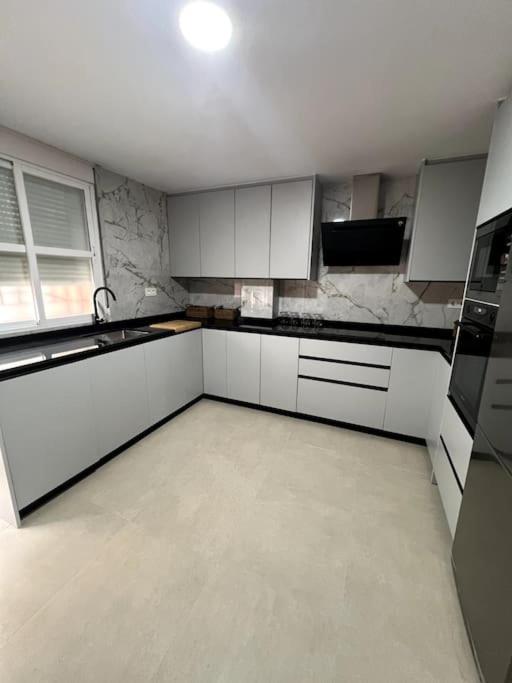 uma cozinha vazia com armários e electrodomésticos brancos em Casa para grupos en Granada em Granada