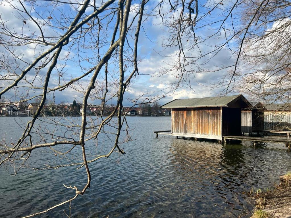 a small building on a dock in the water at Apartment Weßling in Weßling