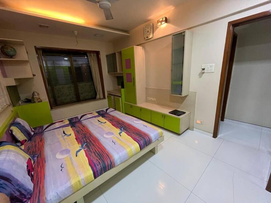 Luxury 4BHK Penthouse with Theatre, Jacuzzi & Private Terrace في نافي مومباي: غرفة نوم بسرير كبير ونافذة