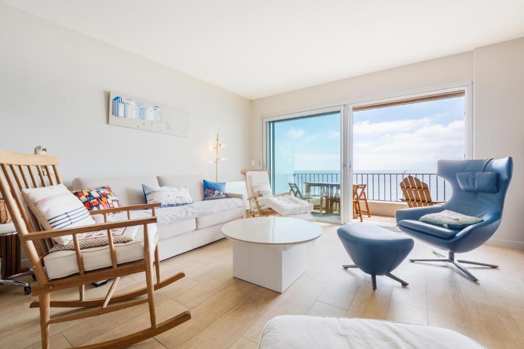 ラ・ボールにあるCASSIOPEE - Face MERのリビングルーム(白いソファ、青い椅子付)