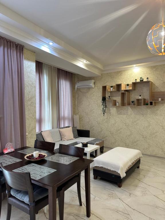 sala de estar con mesa y sofá en Rustaveli Apartment 113, en Kutaisi