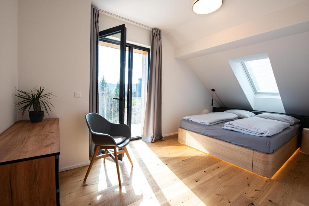 a bedroom with a bed and a desk and a chair at Ski&Bike horský apartmán 502 in Janske Lazne