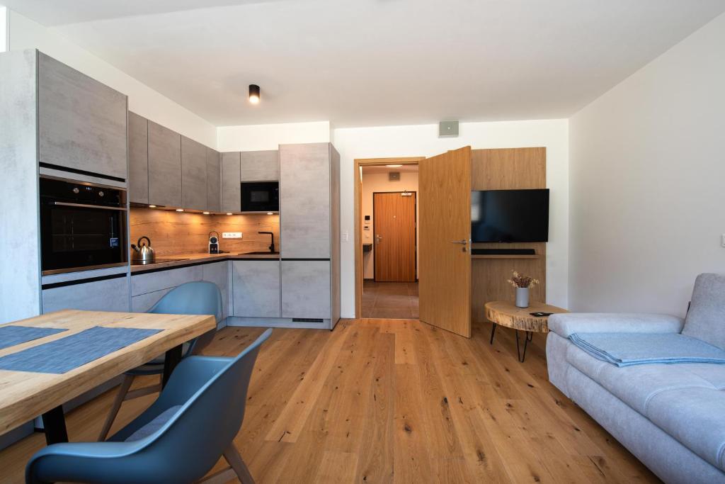 a kitchen and living room with a table and a couch at Ski&Bike apartmán INFFINITY in Janske Lazne