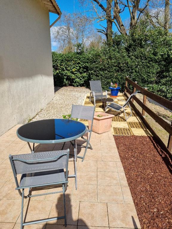 un patio avec une table et des chaises et une clôture dans l'établissement Entre Dordogne et Charente en Nouvelle Aquitaine, à Porchères