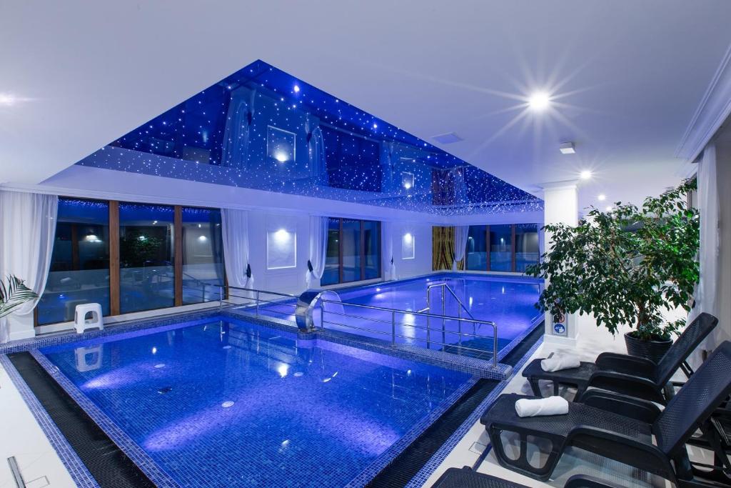 - une piscine dans une maison avec des étoiles au plafond dans l'établissement Pokoje z wyżywieniem i krytym basenem w Amber Park Spa, à Niechorze