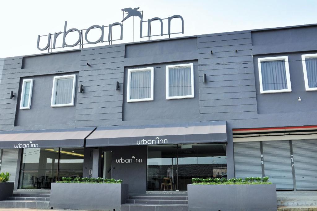 a building with a sign on the front of it at Urban Inn Kulim in Kulim