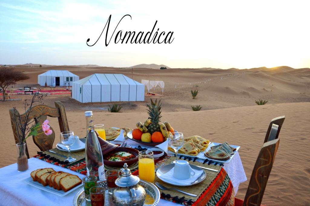 uma mesa com comida no deserto em Nomadica Desert Camp em Merzouga
