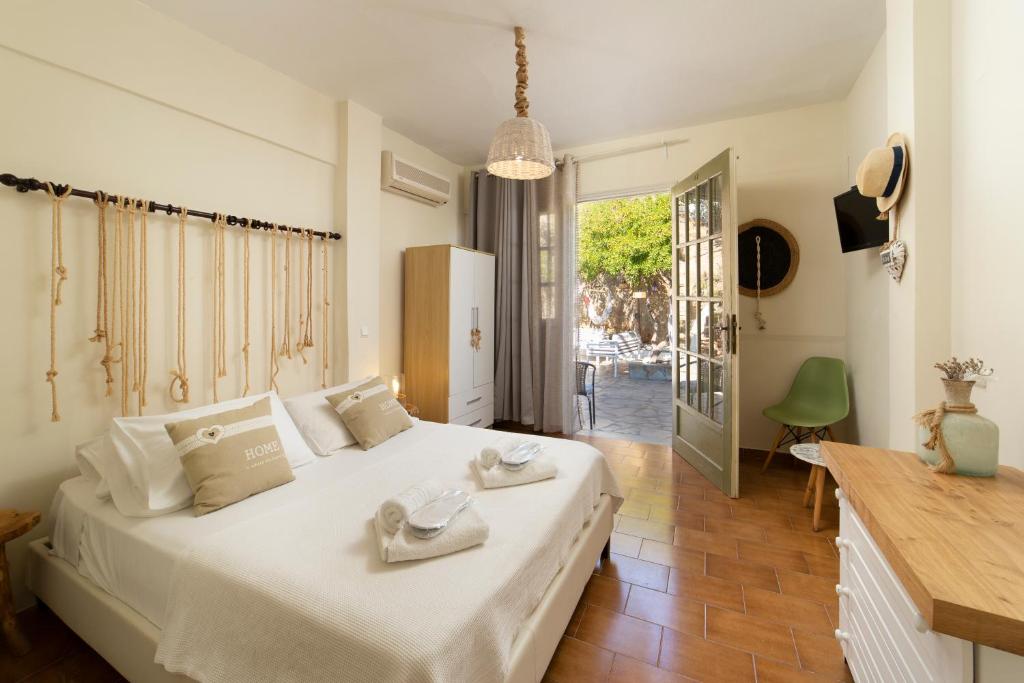 a bedroom with a white bed with towels on it at Villa Fiamegou Andros in Batsi