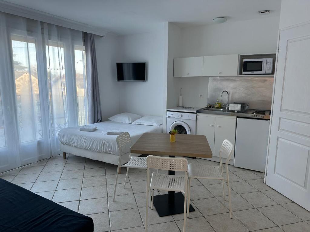 Cet appartement comprend une chambre avec un lit et une table ainsi qu'une cuisine. dans l'établissement Le charme de la Touraine, à Fondettes