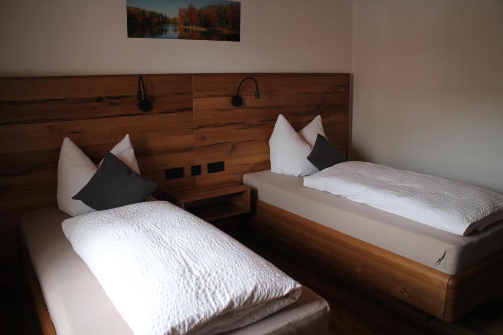 two twin beds in a room with at Gasthaus zum Stausee in Grafenau