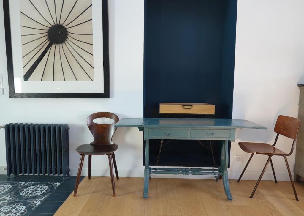 a blue desk with two chairs in a room at Kermaria Studio Suite in Pont-Aven