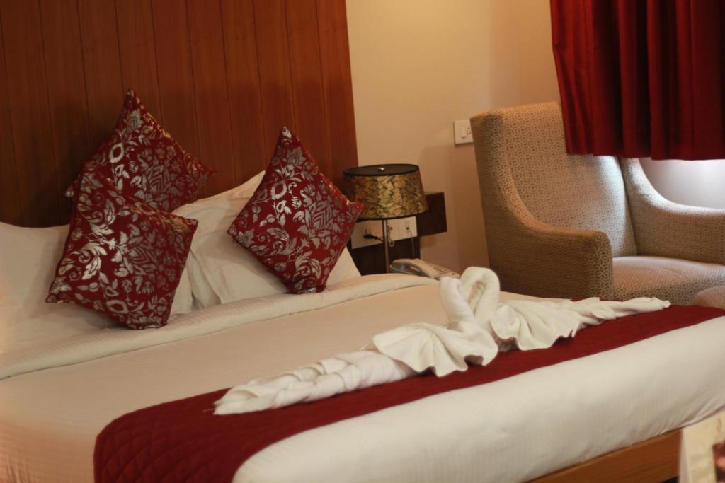 a hotel room with a towel on a bed at Hotel The Amaris in Rishīkesh