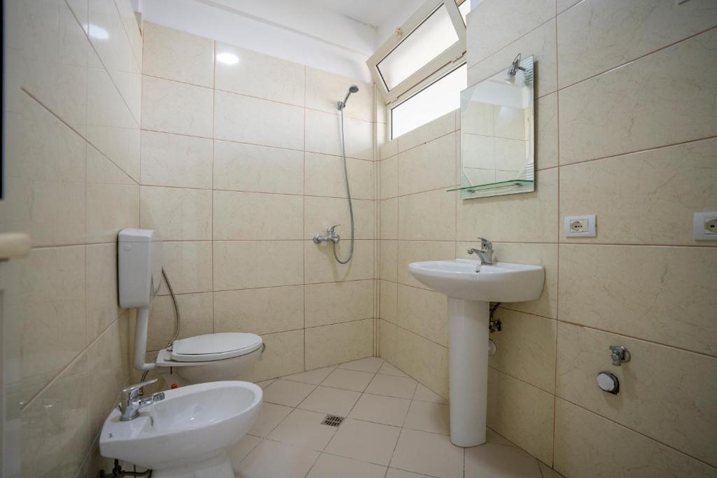 La salle de bains est pourvue d'un lavabo et de toilettes. dans l'établissement Golden Sleep Hostel, à Shkodër