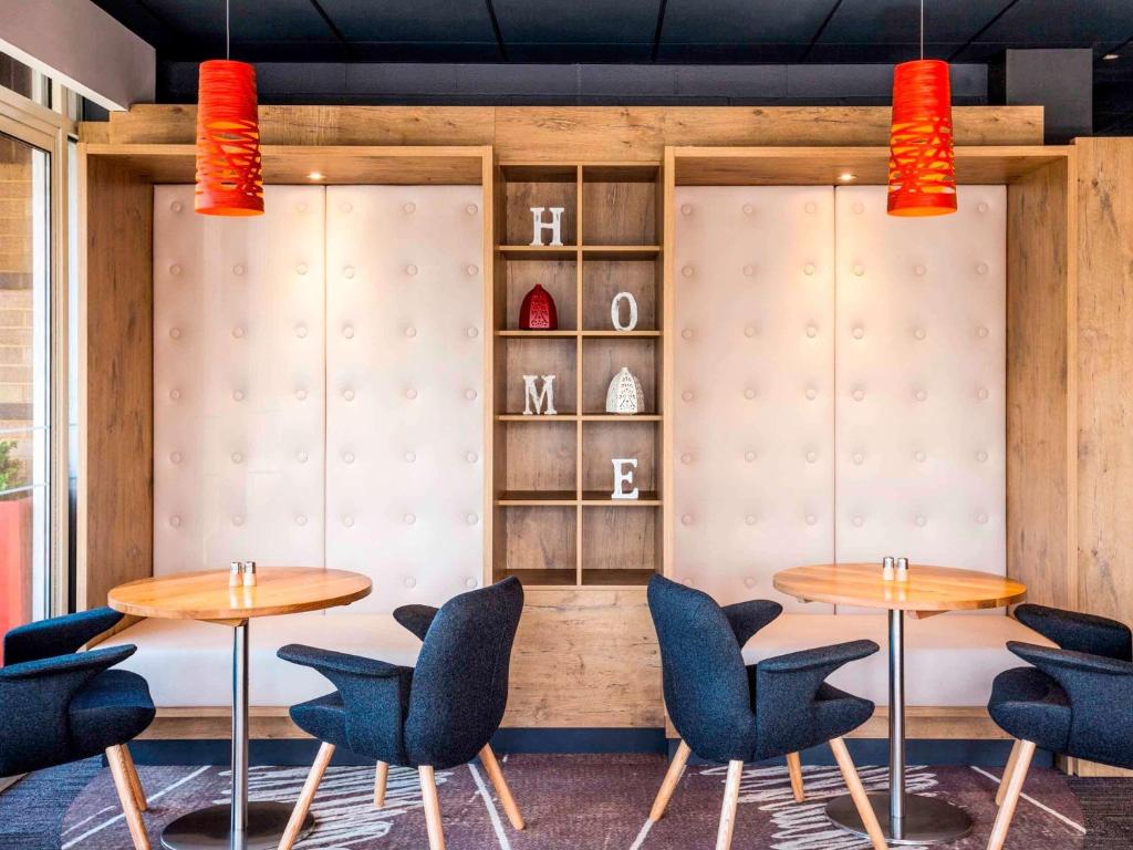 a restaurant with two tables and chairs and shelves at ibis London Elstree Borehamwood in Borehamwood
