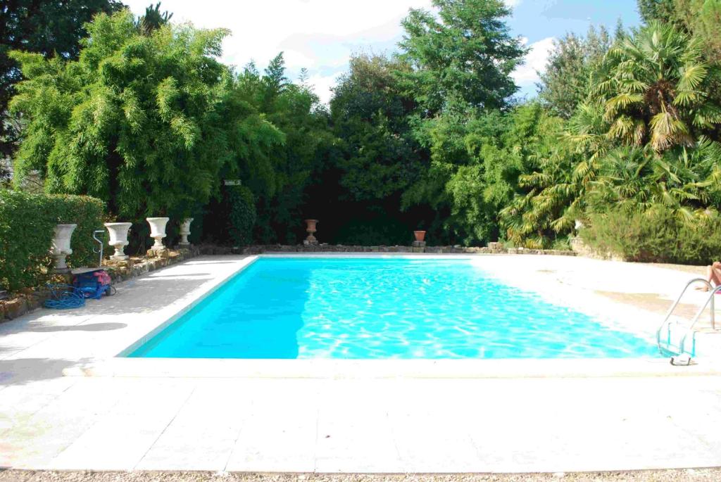 a swimming pool with blue water and trees at Private Villa Dolce Vita in Lucignano