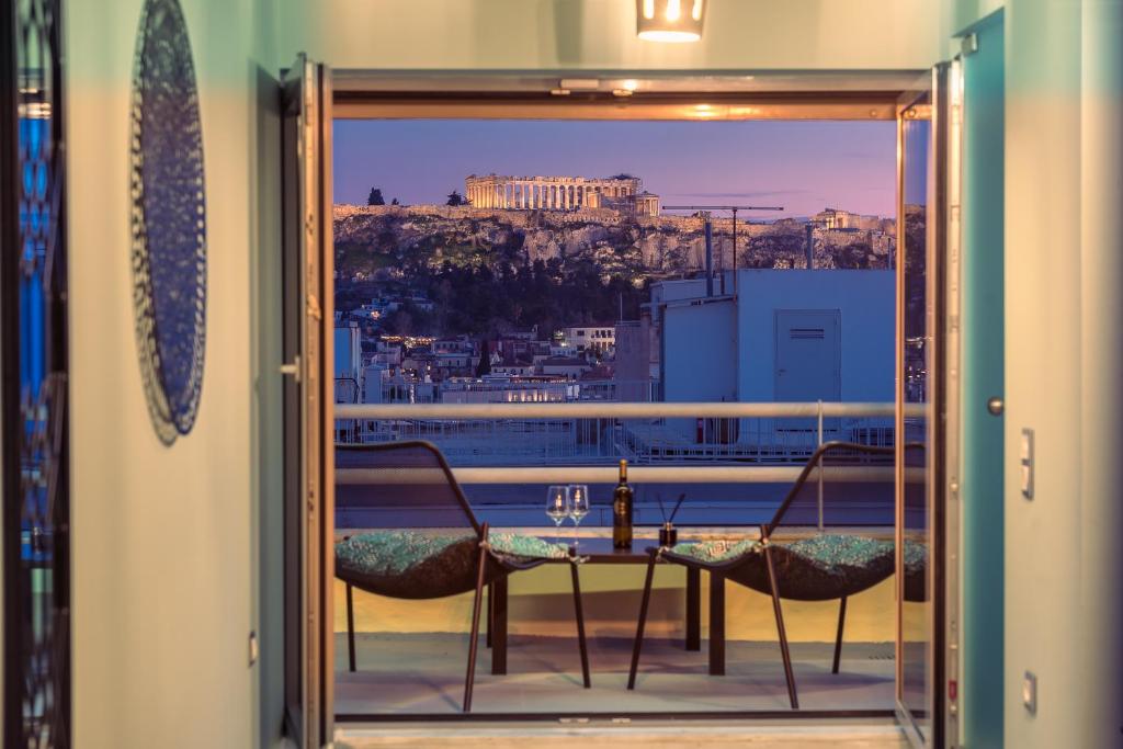 a table and chairs on a balcony with a view ofhens at Acropolis View Mini Sky Suite & Hot Tub in Athens