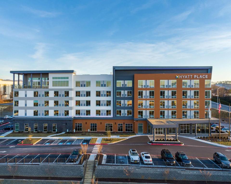 a hotel with cars parked in a parking lot at Hyatt Place Harrisonburg in Harrisonburg