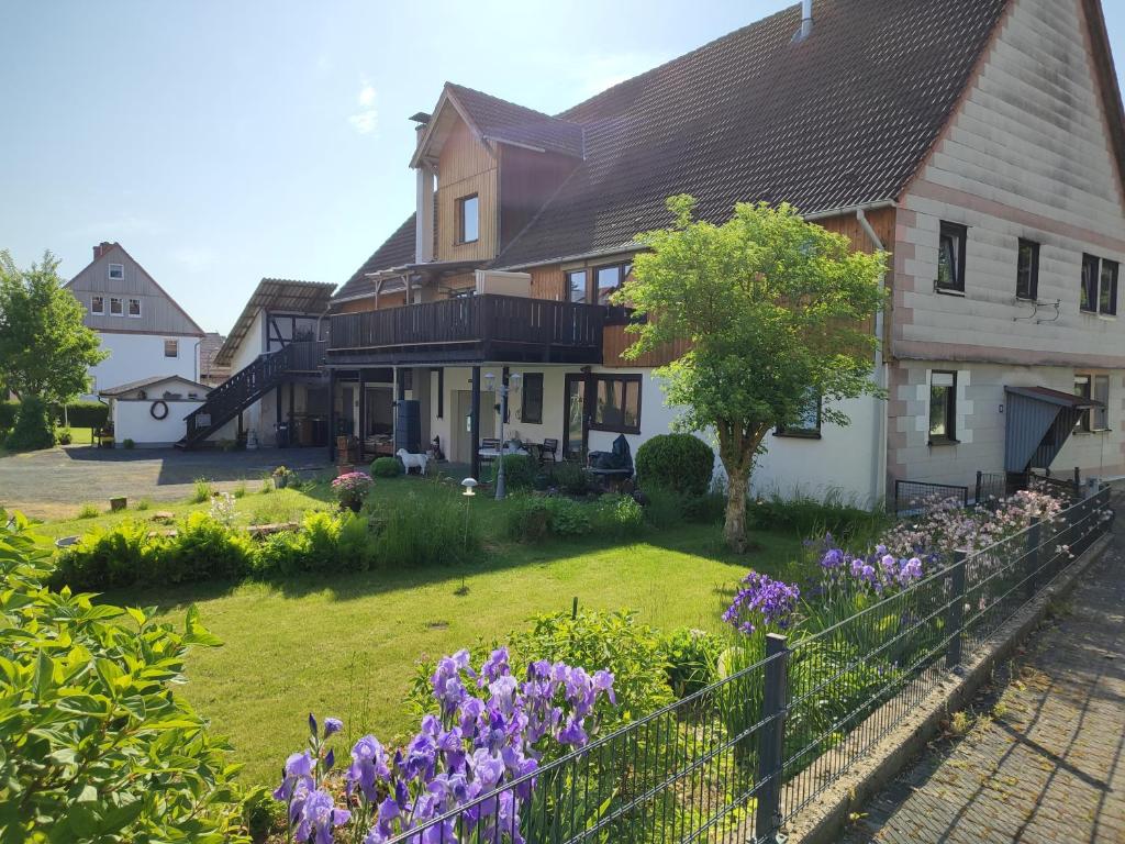 a house with a yard with purple flowers at Ferienwohnung am Rittergut in Grebenstein