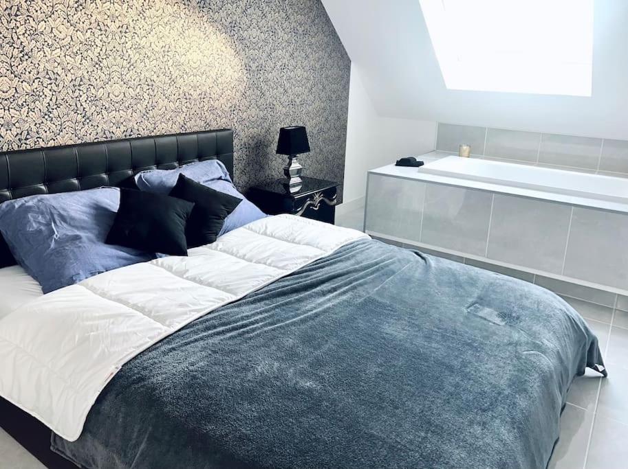 um quarto com uma cama grande e uma banheira em Villa Elaïa maison Familiale Omaha Beach em Saint-Laurent-sur-Mer
