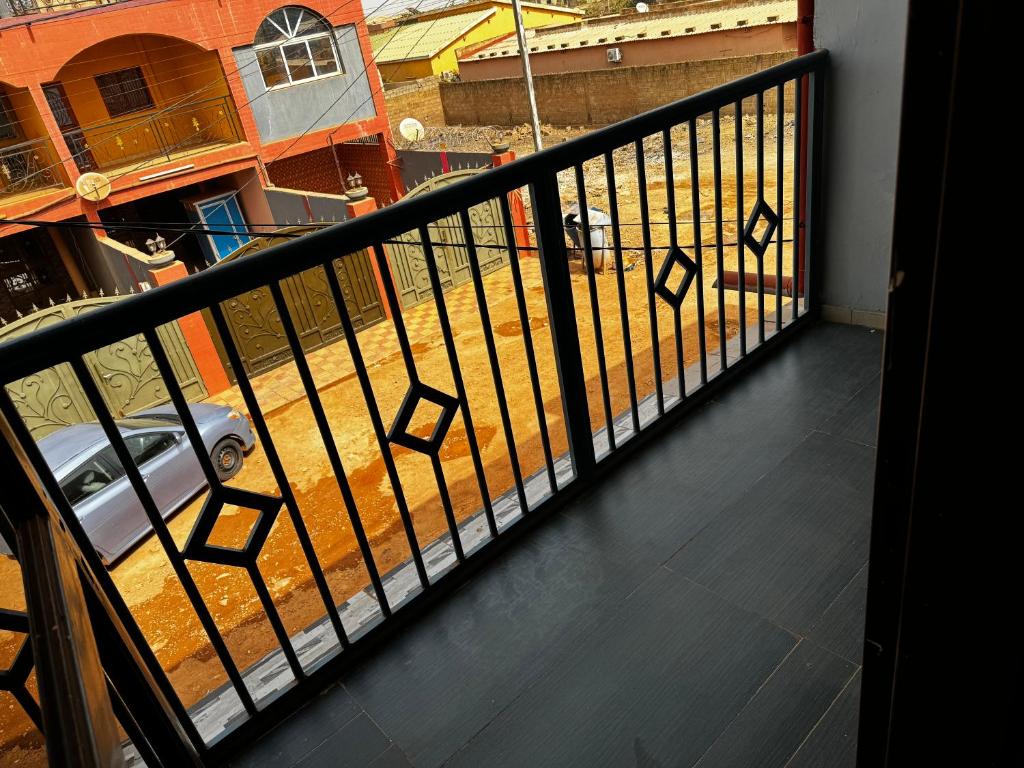 a balcony with a railing with a car on it at Prestige House in Ouagadougou