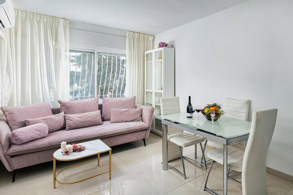 a living room with a pink couch and a table at Modern Living in Kings Courtyard in Jerusalem