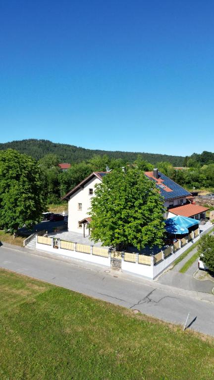 ein weißes Haus am Straßenrand in der Unterkunft Gasthaus zum Stausee in Grafenau