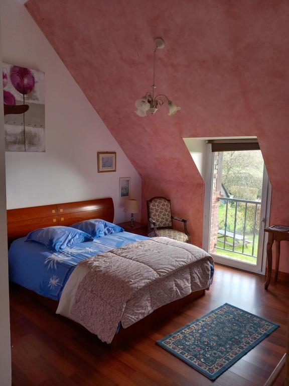 ein Schlafzimmer mit einem Bett und einer roten Wand in der Unterkunft B AND B Chambres d'Hôtes Les Falaises in Saint-Léonard