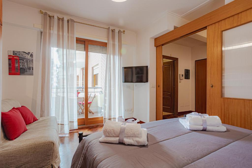 - une chambre avec 2 lits et des serviettes dans l'établissement HOME SWEET HOME, à Acilia