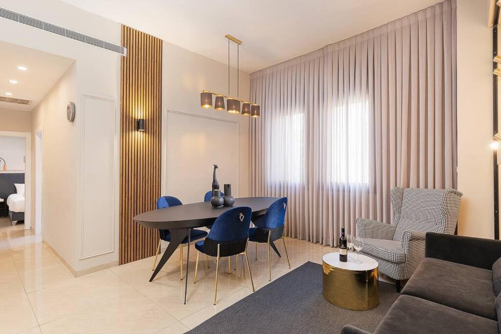 - un salon avec une table et des chaises bleues dans l'établissement Yefeh Nof - City Center 2BR Apartment, à Jérusalem
