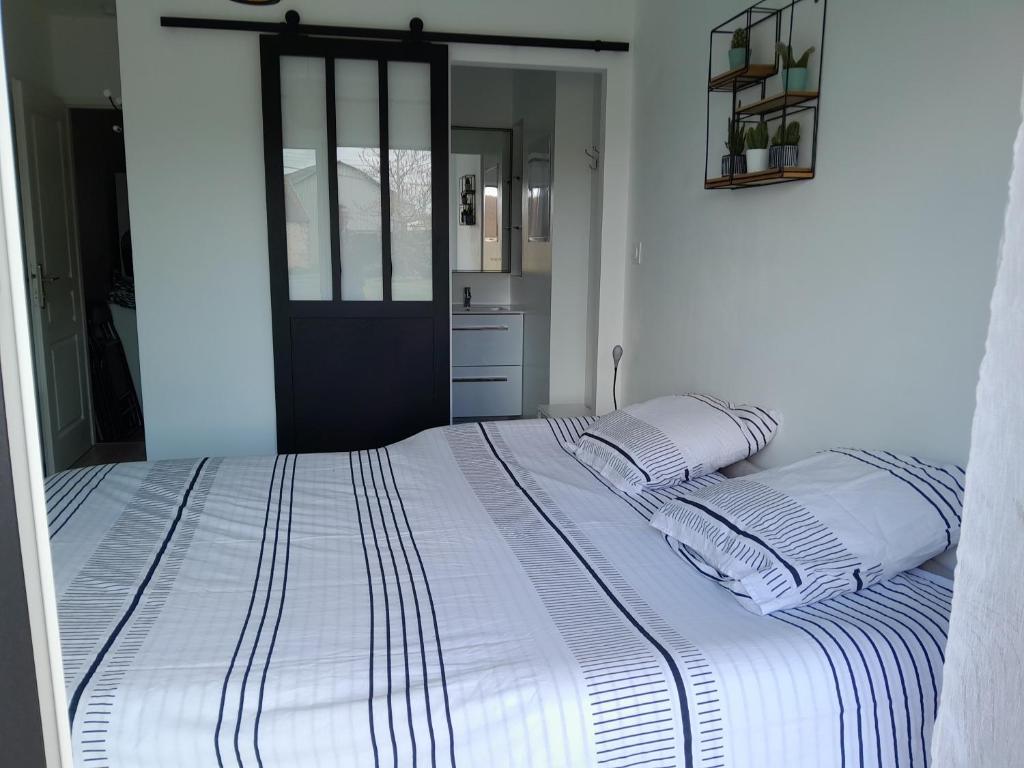 ein Schlafzimmer mit einem großen weißen Bett mit zwei Kissen in der Unterkunft Chez Maryline in Chalonnes-sur-Loire