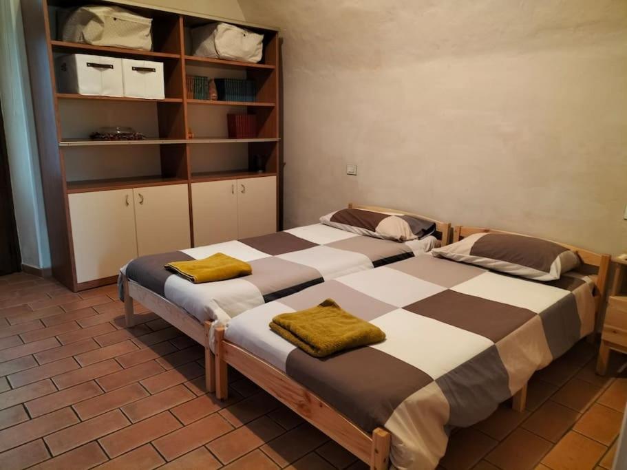 a bedroom with two beds and a book shelf at Il Nido di Concesio in Concesio