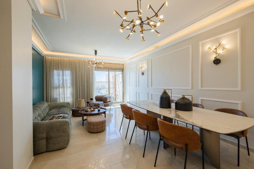 eine Küche und ein Wohnzimmer mit einem Tisch und Stühlen in der Unterkunft City Lights 4 BR Stunning Apart in Jerusalem