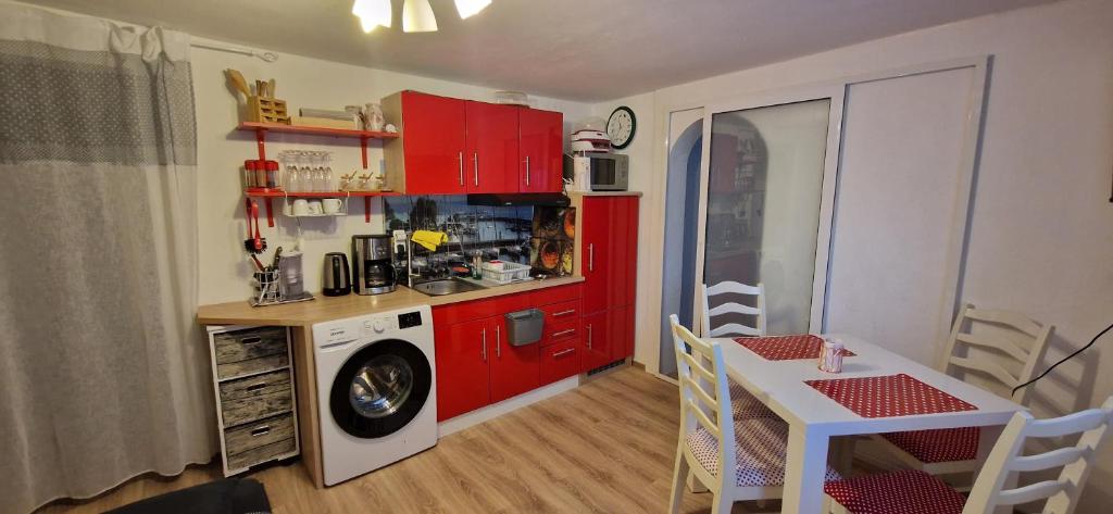 cocina con armarios rojos y lavadora en Orchidee 2, en Radolfzell am Bodensee