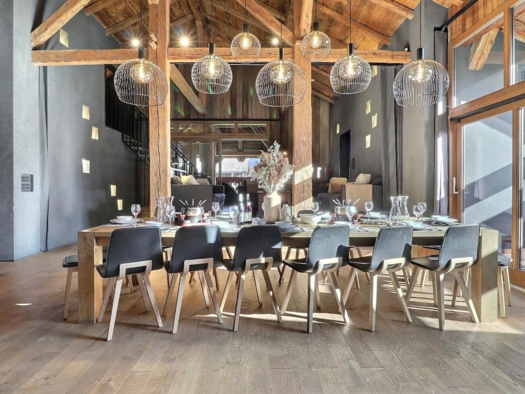 a dining room with a table and chairs and lights at Chalet Morzine, 9 pièces, 14 personnes - FR-1-627-9 in Morzine