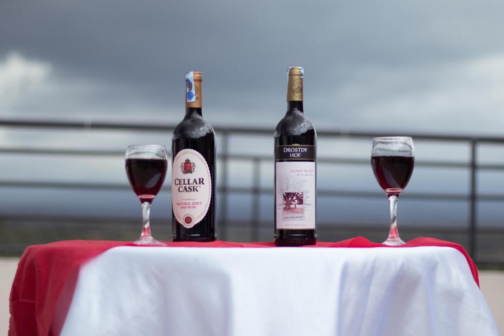 - deux bouteilles de vin rouge sur une table avec des verres dans l'établissement Africa One Hotel, à Nanyuki
