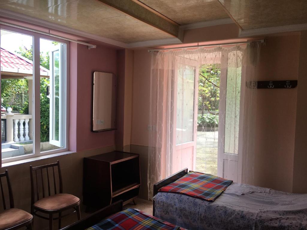 um quarto com uma cama e uma janela em Дом тсивадзе em Kobuleti