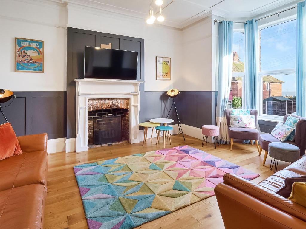 a living room with a couch and a fireplace at Belmont House in Broadstairs