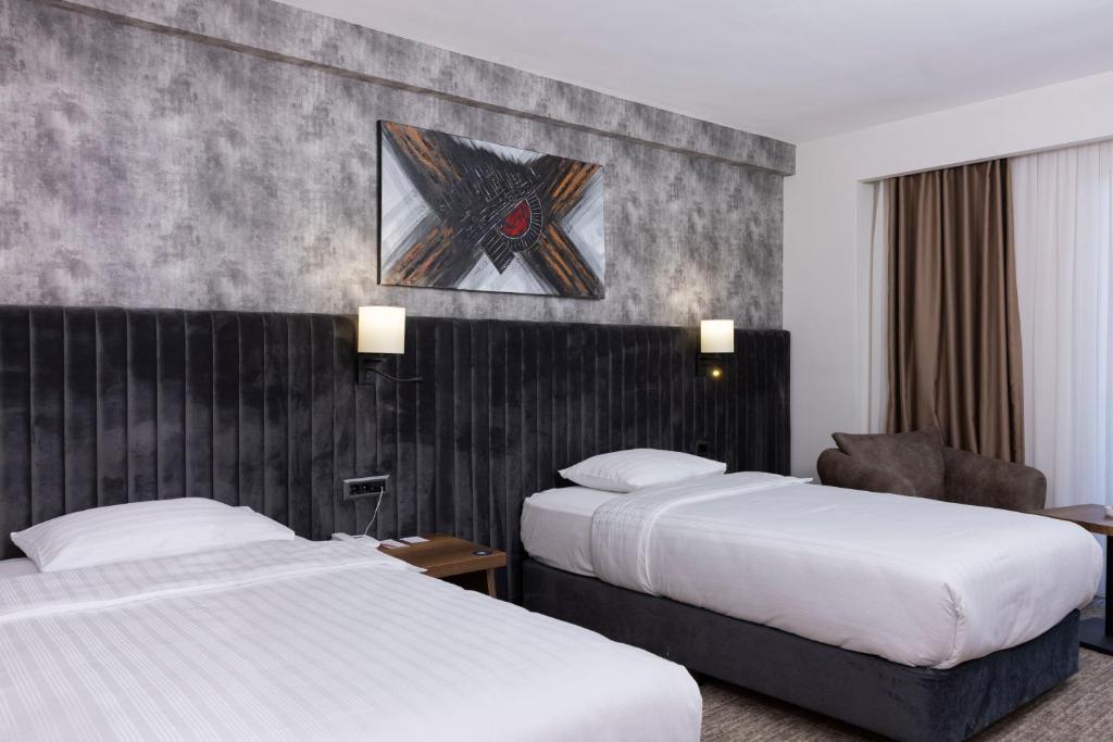 una habitación de hotel con 2 camas y una silla en Anemon Karabük Hotel, en Karabük