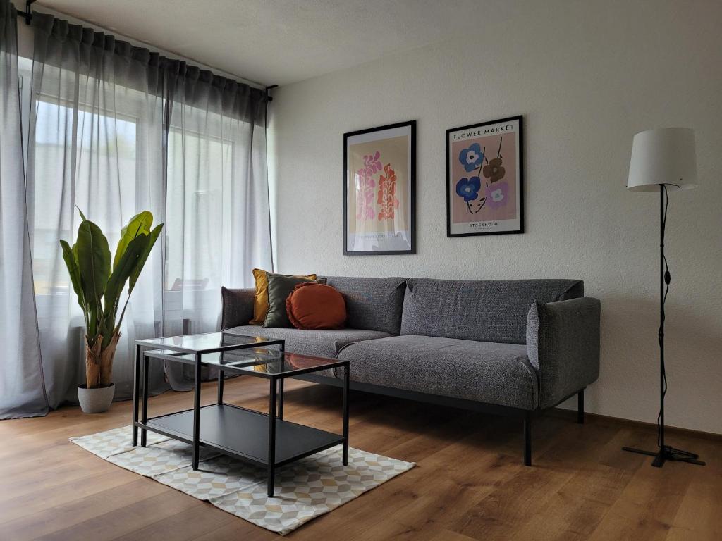 a living room with a couch and a glass table at Living Flat, eine Wohnung mit zwei Schlafzimmern und Balkon in Schorndorf
